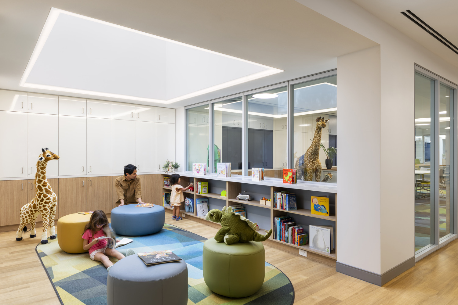 Play area with seating and book shelves under a skylight